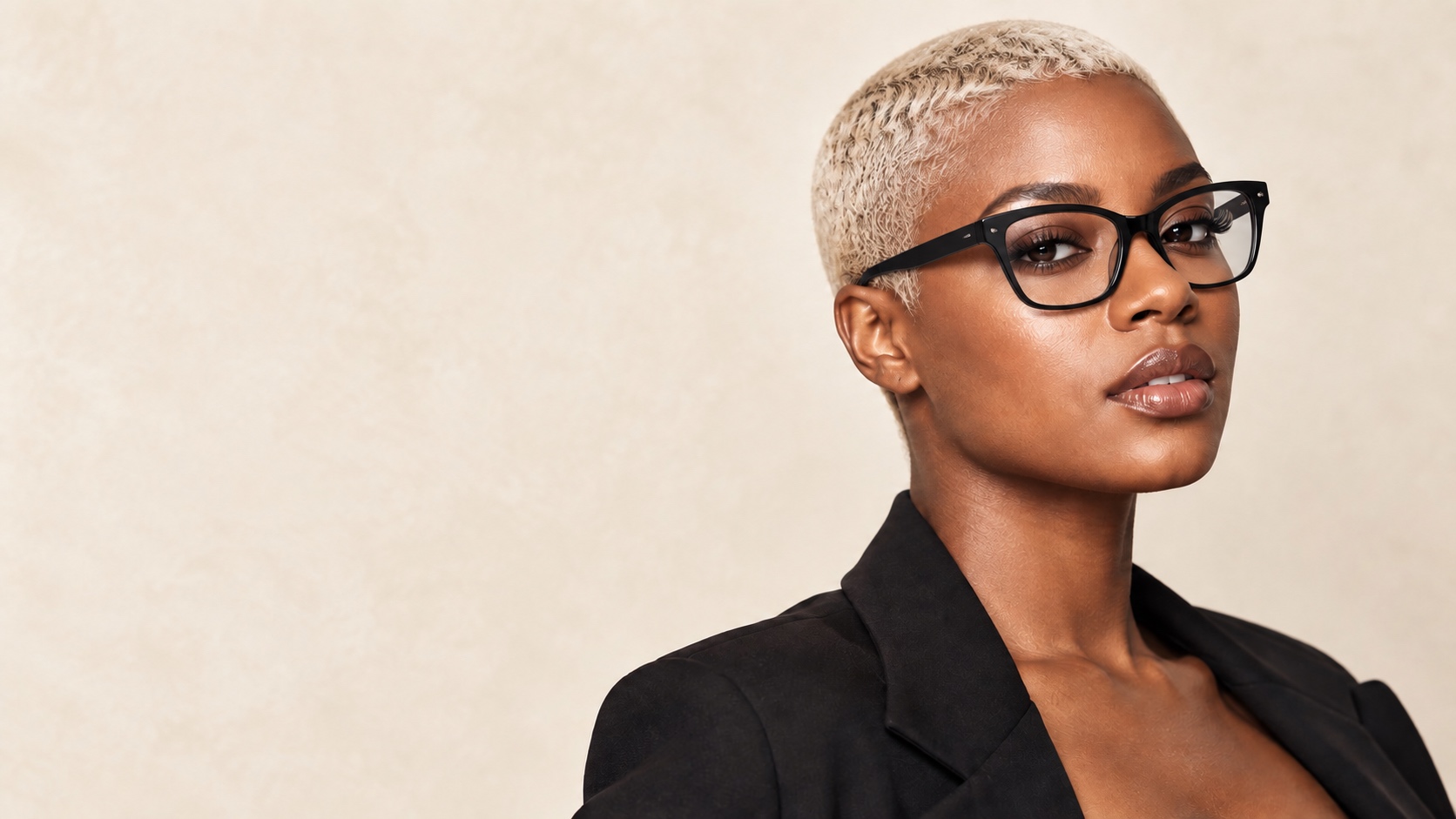 Black woman in stylish black optical glasses with a very short super-bleached platinum micro-cut