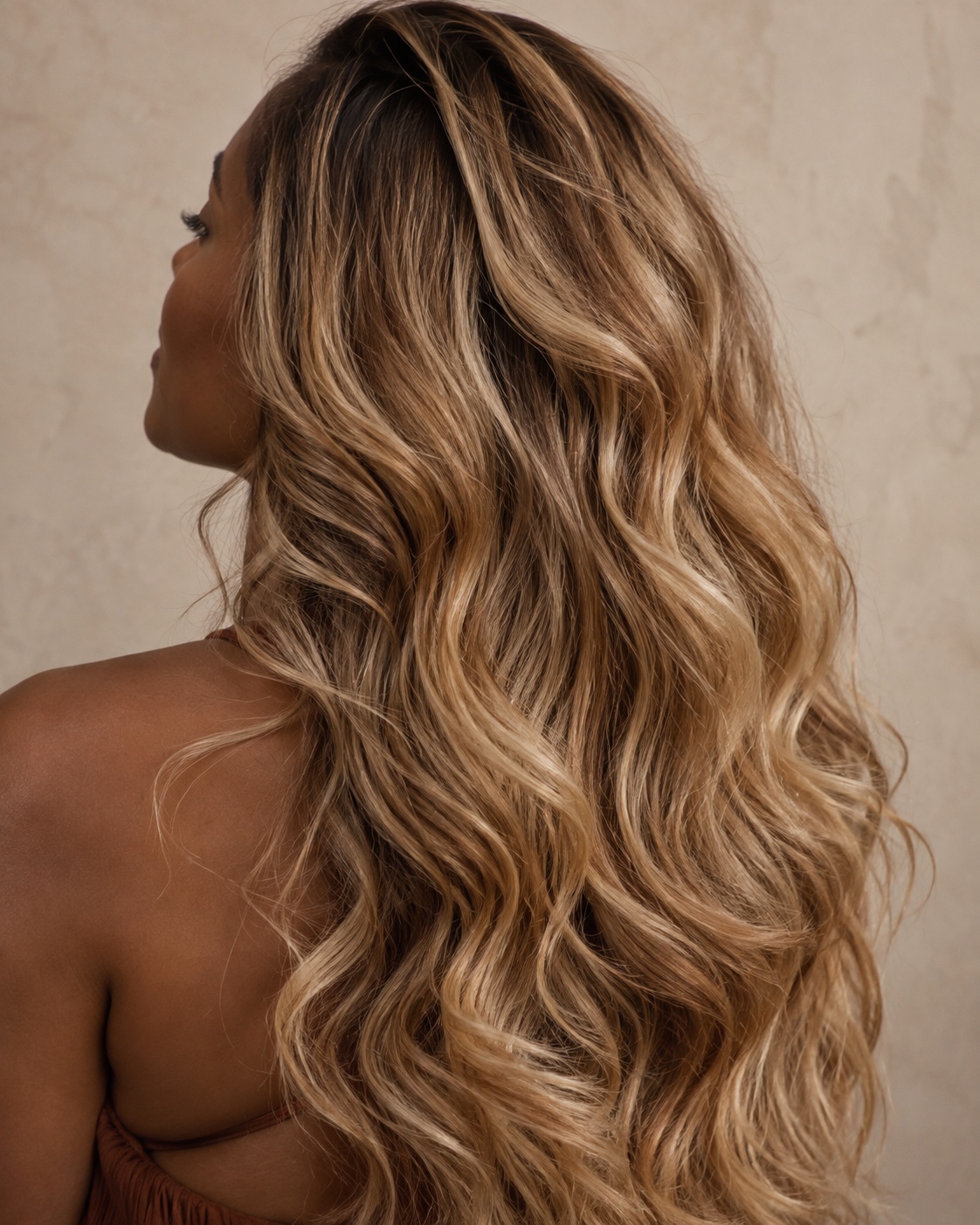 Close-up of long dimensional soft-maple-blonde waves with honey and caramel ribbons